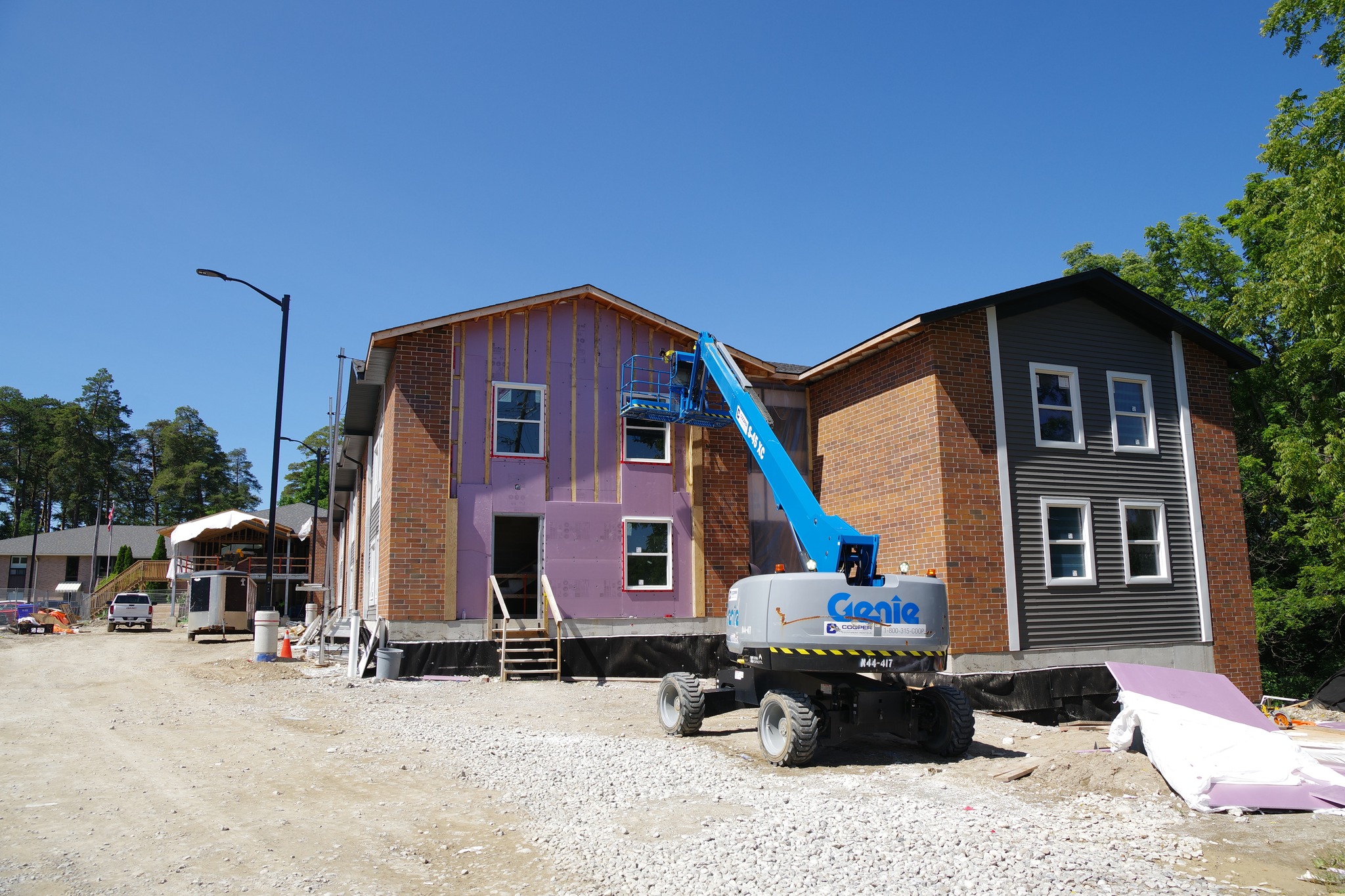Two story apartment building under construction with a blue crane in front